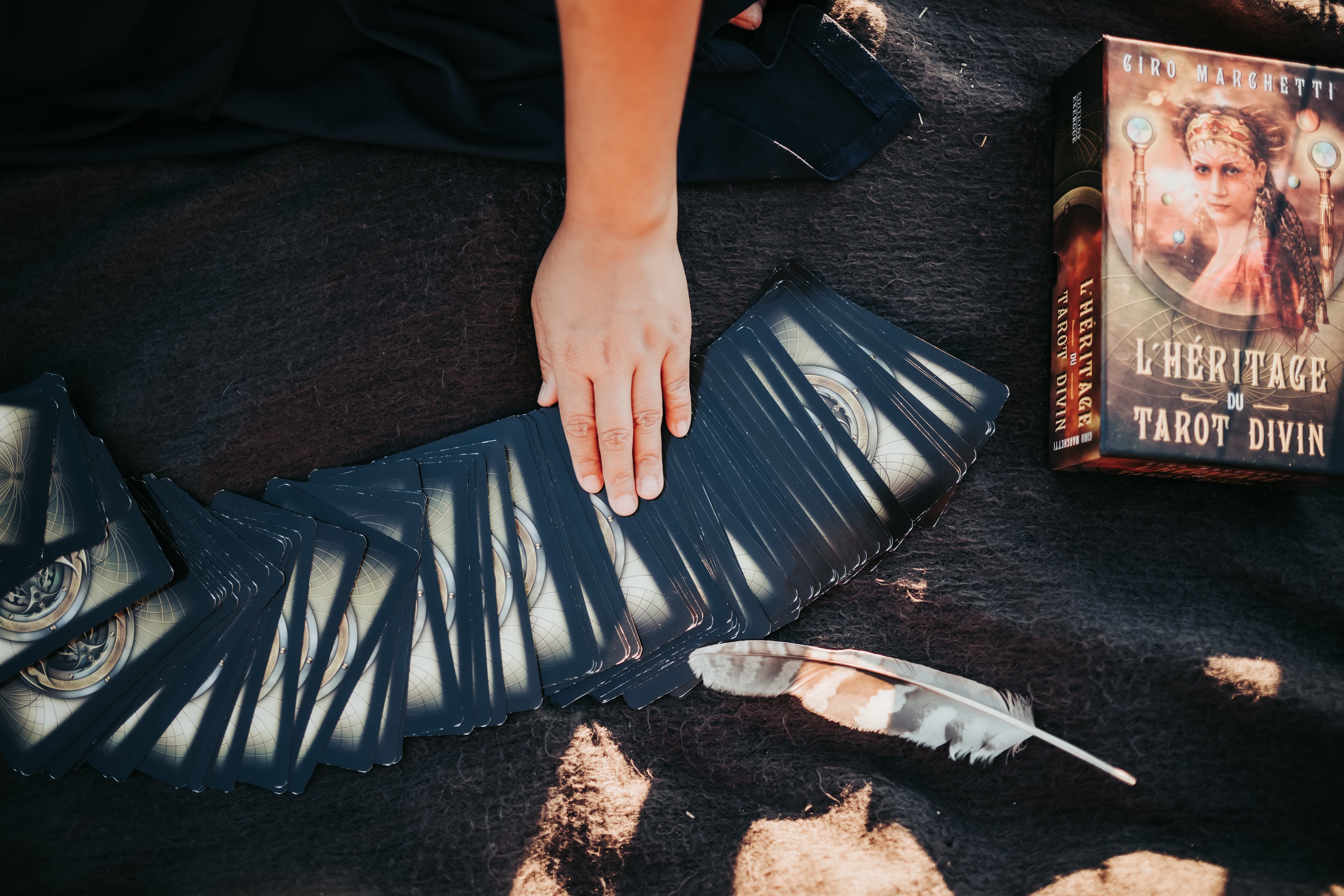 gros plan sur des cartes de tarot et une main, lors d'une guidance exercée par une thérapeute en constellations familiales et systémiques et thérapie psycho-spirituelle exerçant à Lausanne, Morges et Renens dans le canton de Vaud en Suisse romande