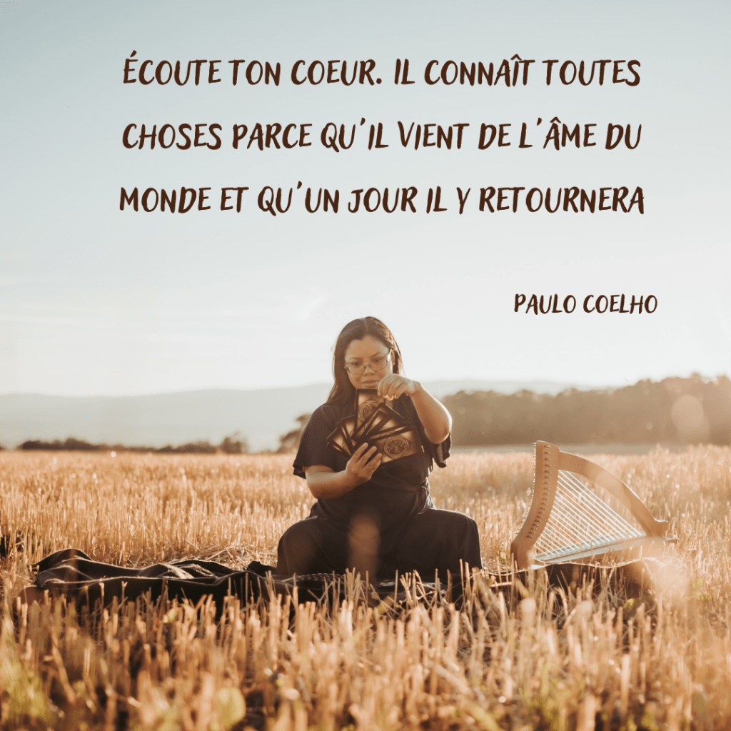 image d'une praticienne en constellations familiales et systémiques et thérapie psycho-spirituelle exerçant les guidances par le tarot, assise dans un champ de blé au soleil couchant dans la région de Morges et Renens, près de Lausanne en Suisse