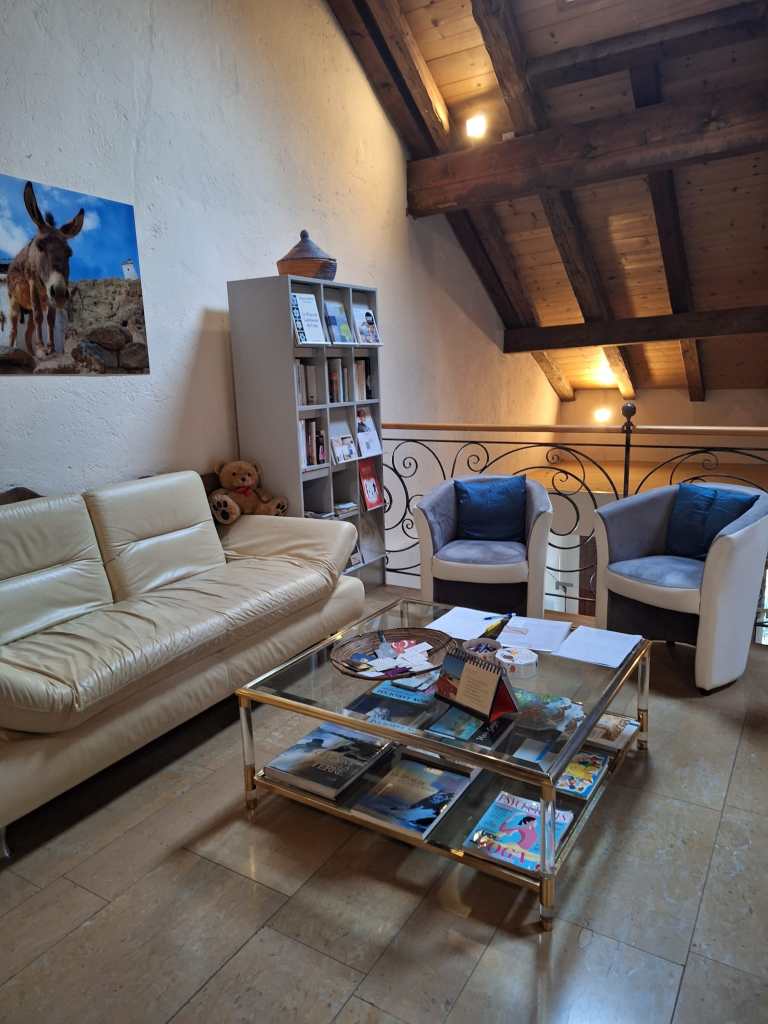 illustration de la salle d'attente du Château de Renens-sur-Roche à Renens, dans le canton de Vaud, un espace de thérapie holistique où se déroulent des journées de constellations familiales et systémiques en groupes et des séances de thérapie psycho-spirituelle